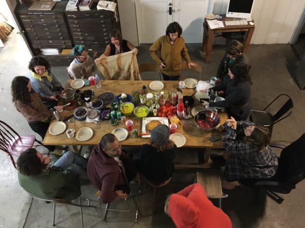 Members of Real Time and Space eating around a large table.